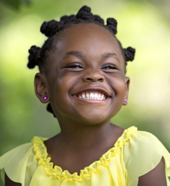 Child with healthy smile after fluoride treatment