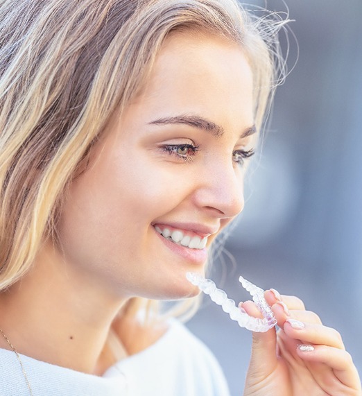 woman smiling about undergoing Invisalign in Plano