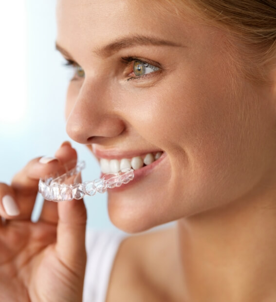 Woman placing Invisalign clear braces tray