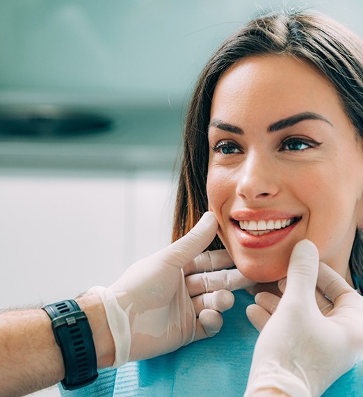 Dentist holding veneer with tweezers